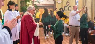 father-john-mcevoy-gives-communion-stephen-okey-blesses-student